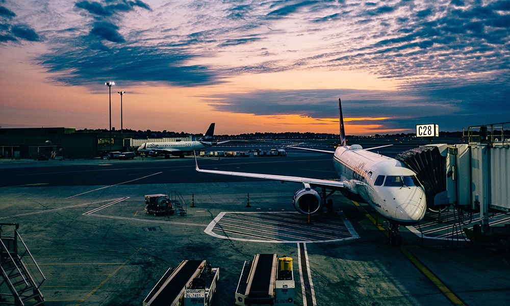 travelers boarding an airplane from the jet bridge