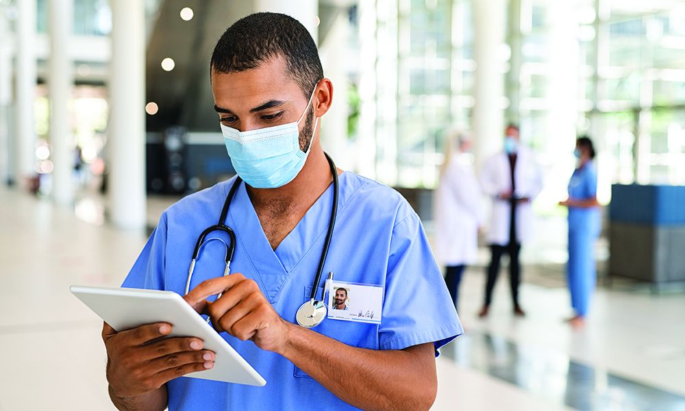 Mixed Race Nurse Using Digital Tablet At Hospital