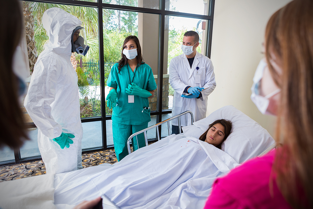 Hospital staff wearing masks and protective gear around infected patient