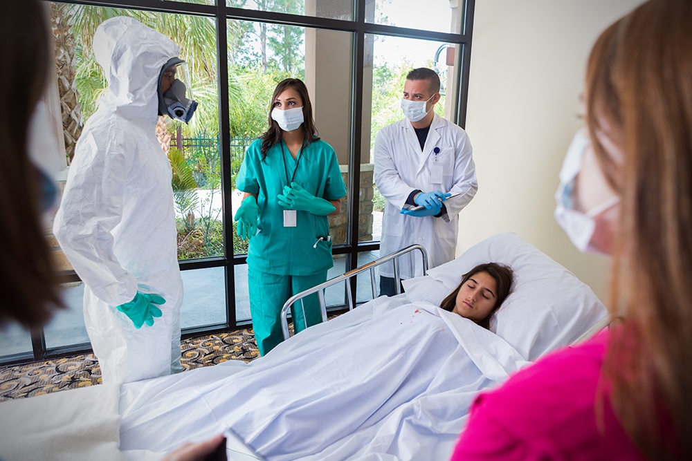 Hospital staff wearing masks and protective gear around infected patient