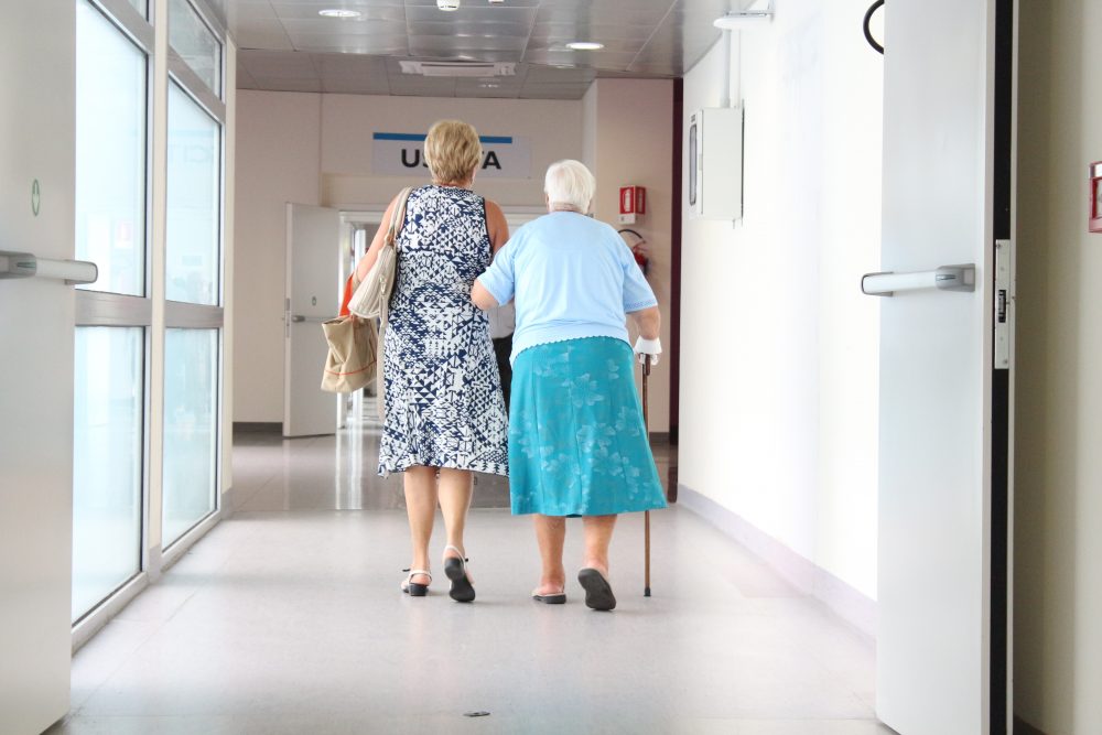 nursing home covid-19 long-term care facility Adult Woman Walking with Her Senior Mother in the Hospital