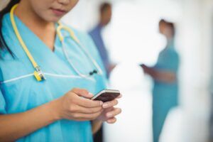 Nurse using mobile phone for clinical collaboration