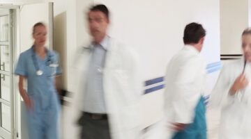 Doctors in hospital corridor practicing clinical collaboration