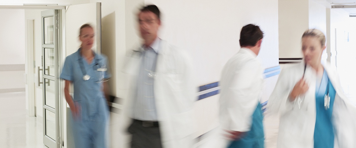 Doctors in hospital corridor practicing clinical collaboration
