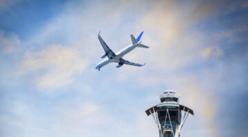 Airplane Flying Over Air Traffic Control Tower