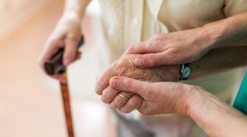 two hands supporting and elderly individual