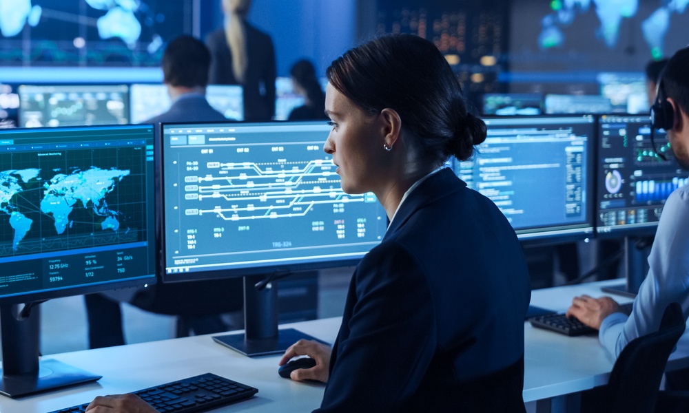 Team Of Professional Computer Data Science Engineers Work On Desktops With Screens Showing World Map, Charts, Graphs Infographics Technical Business Data And Statistics. Dark Control Monitoring Room.