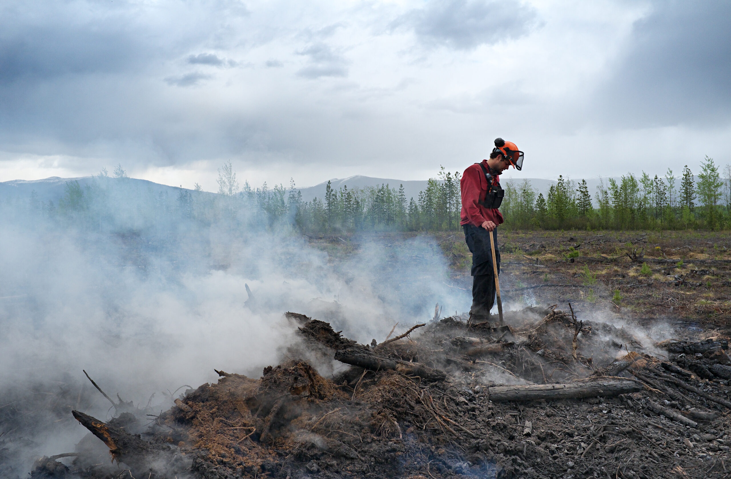 Firefighter Standing On Top Of A Smoldering Pile